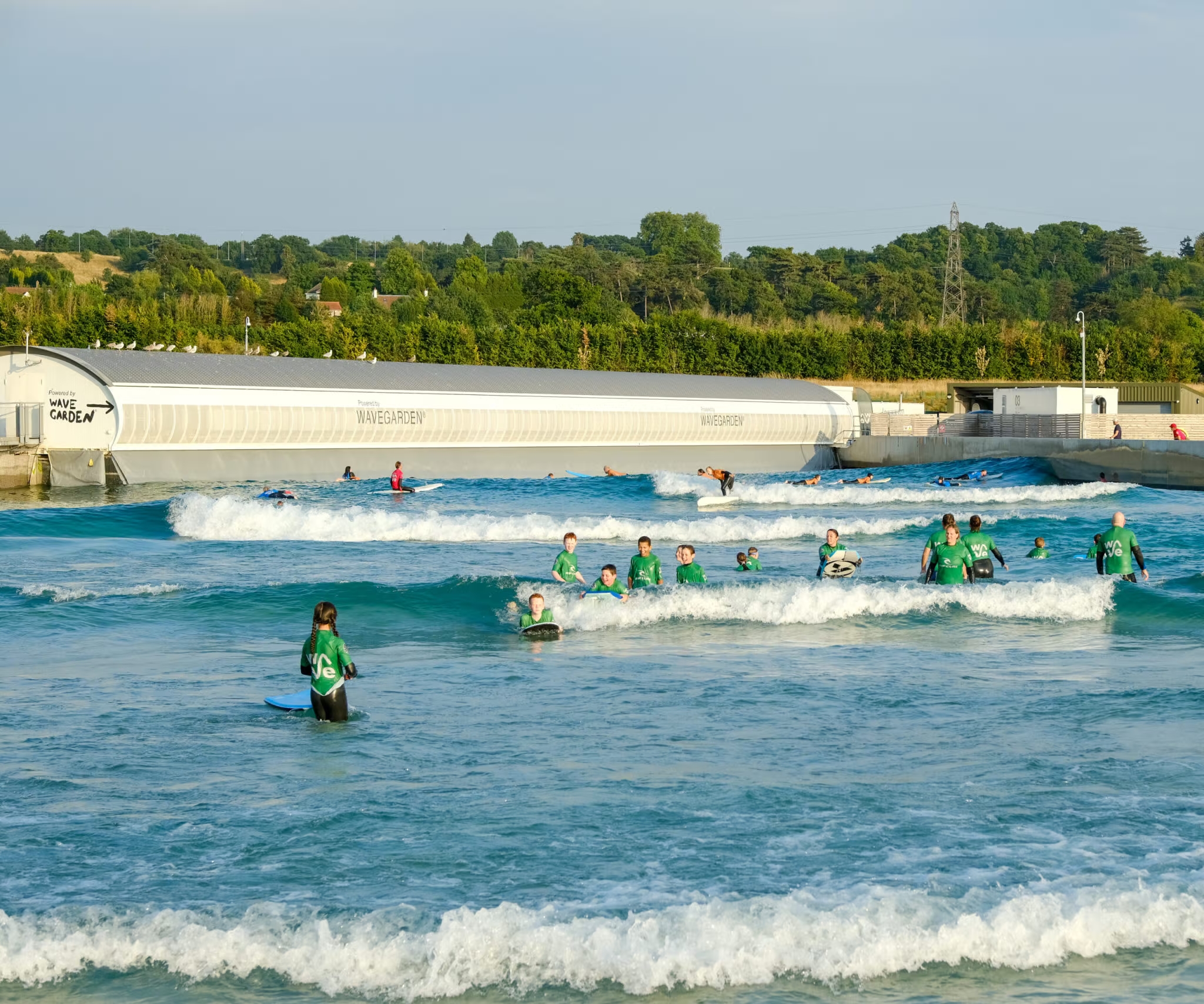 Des enfants apprennent le surf à The Wave, la piscine à vagues artificielles construite à Bristol avec la technologie Wavegarden